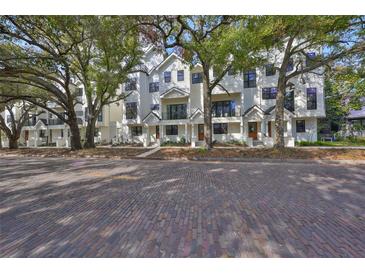 New white townhouse exterior featuring a brick road and mature trees on an idyllic street at 1801 N Morgan St # 5, Tampa, FL 33602