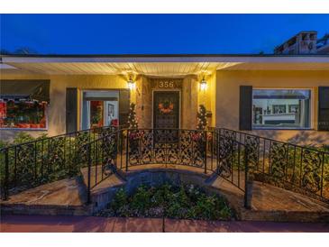 Inviting front entrance featuring decorative iron railings, stone walkway, and elegant lighting at 356 20Th Ne Ave, St Petersburg, FL 33704