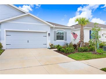 Charming single-story home with a well-manicured lawn, a two car garage, and a beautiful palm tree at 3719 Stormy Thistle Pl, Plant City, FL 33565