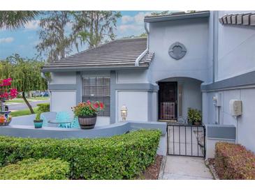 Charming home exterior features a gated courtyard with seating and garden, showcasing the property's curb appeal at 4234 Brentwood Park Cir, Tampa, FL 33624