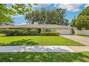 Charming single story home with a manicured lawn, trimmed hedges, and a two car garage at 512 Hillpine Way, Brandon, FL 33510
