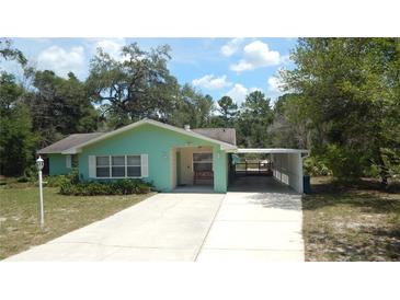 Ranch-style home boasts a welcoming porch, spacious driveway, and charming curb appeal at 5287 Azalea Cir, Dade City, FL 33523