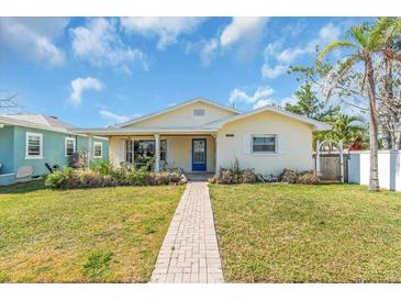 Charming one-story home with a well-manicured lawn and a brick walkway leading to a covered porch at 5713 Shore S Blvd, Gulfport, FL 33707