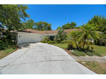 Charming single-story home featuring a well-manicured lawn and driveway leading to a two-car garage at 60 Lakeview Ct, Palm Harbor, FL 34683