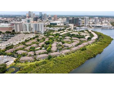 Beautiful aerial view of Island Walk private residences surrounded by lush greenery and waterfront with the city in the background at 612 Arbor Lake Ln, Tampa, FL 33602