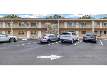 Exterior view of a two-story building with ample parking, featuring a stone accent wall at 8039 Garden Dr # 105, Seminole, FL 33777