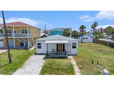 Charming single-story home featuring a cozy front porch and a classic white facade at 13124 4Th E St, Madeira Beach, FL 33708