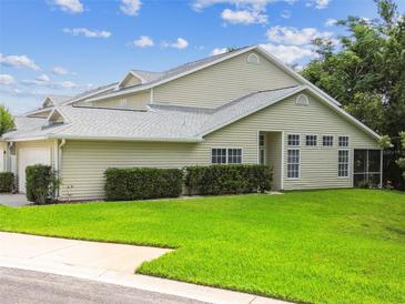 Well-maintained home featuring manicured lawn, hedges, and a screened-in porch for relaxing outdoor living at 1624 Lullwater Ln, Lutz, FL 33549