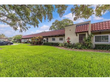 Charming single-story villa featuring a well-maintained lawn and beautiful landscaping at 1701 Pinehurst Rd # 9G, Dunedin, FL 34698
