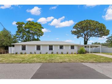 Charming single-story home featuring a well-maintained lawn, carport and beautiful mature trees at 2907 W Tyson Ave, Tampa, FL 33611
