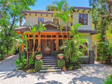 Beautiful two-story home featuring a wooden front porch and mature tropical landscaping at 3112 W Wallcraft Ave, Tampa, FL 33611