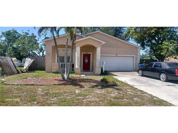 Charming single-Gathering home featuring a well-kept yard, attached garage, and inviting entryway with red door at 3680 19Th S Ave, St Petersburg, FL 33711