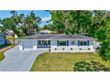 Charming single-story home with a well-manicured lawn, a paved driveway, and delightful blue exterior accents at 4321 Sunrise S Dr, St Petersburg, FL 33705