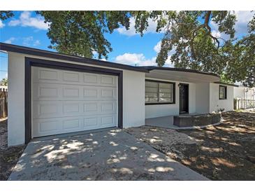 Charming single-story home featuring a white exterior, well-maintained garage, and inviting front porch at 5053 Lofton Dr, New Port Richey, FL 34652