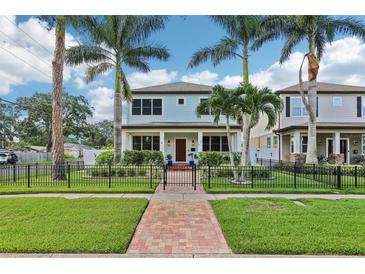 Charming two-story home with manicured lawn, mature palms, and a decorative fence at 510 33Rd N Ave, St Petersburg, FL 33704