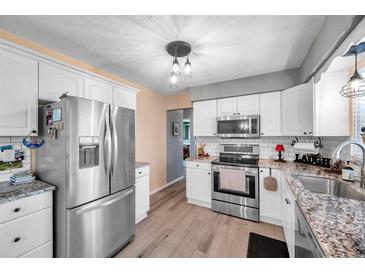 Modern kitchen with stainless steel appliances, granite countertops, and hardwood floors at 11348 59Th Ter, Seminole, FL 33772
