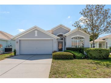Charming single-story home featuring a well-manicured lawn and attached two-car garage at 2747 Wood Pointe Dr, Holiday, FL 34691