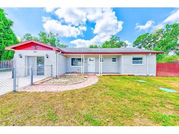 Charming single-story home featuring a brick exterior, well-manicured lawn, and inviting front porch at 521 E Lumsden Rd, Brandon, FL 33511