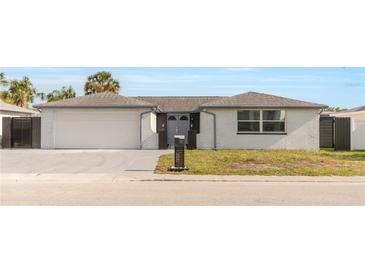 Charming one-story home featuring a large garage, tidy landscaping, and a freshly painted exterior at 6240 Keller Dr, Port Richey, FL 34668