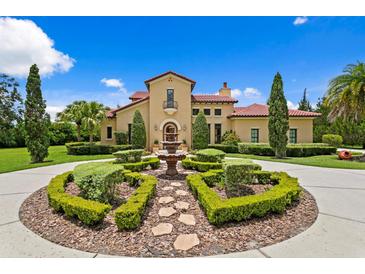 Stunning Mediterranean home with a circular driveway, fountain, and lush landscaping at 7713 Still Lakes Dr, Odessa, FL 33556