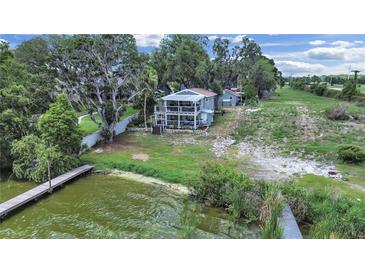 Lovely waterfront home on a large lot with a dock and screened balconies overlooking the lake at 11337 Knights Griffin Rd, Thonotosassa, FL 33592