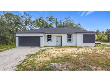 Newly constructed single-Gathering home with a modern black-and-white design and attached garage at 16134 Libourn Ave, Port Charlotte, FL 33954