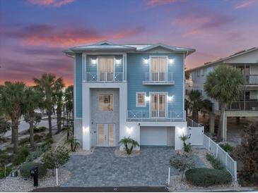 Stunning two-story blue home with white trim, balconies, a paved driveway, and tropical landscaping at 2 Gulf Blvd, Indian Rocks Beach, FL 33785