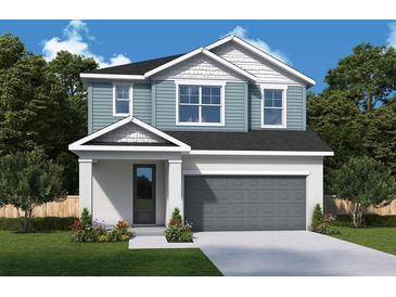Charming two-story home featuring a two-car garage, a well-manicured lawn, and professionally landscaped flower beds at 31343 Pendleton Landing Cir, Wesley Chapel, FL 33545