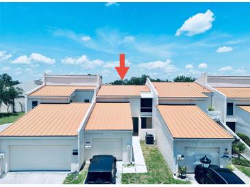 Beautiful condo featuring an attached garage with a well-maintained, manicured lawn in a desirable community at 4360 Outrigger Ln, Tampa, FL 33615