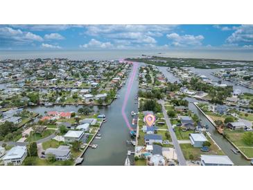Aerial view of waterfront homes along canal with direct access to bay and the open waters beyond at 4976 Cedarbrook Ln, Hernando Beach, FL 34607