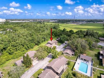 An aerial view of condos and beautiful greenery showcasing the community pool and surrounding landscape at 507 E Curlew Pl, Tarpon Springs, FL 34689
