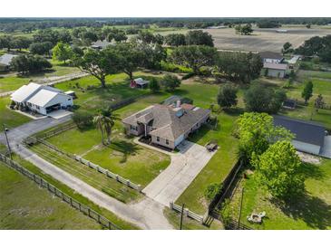 Aerial view of a charming single-Gathering home with a spacious yard and long driveway surrounded by mature trees at 611 Robinson Oaks Ln, Plant City, FL 33567