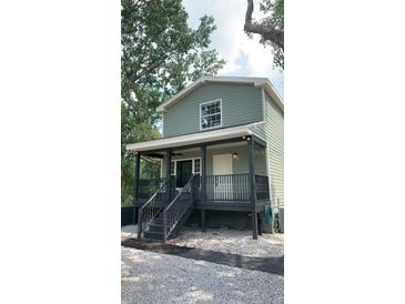 Charming two-story home features a welcoming front porch with sleek, modern railings at 7152 Sandy Ln, Wesley Chapel, FL 33544