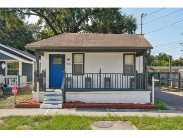 Charming single-story home with a welcoming front porch and a vibrant blue door at 909 E 28Th Ave, Tampa, FL 33605