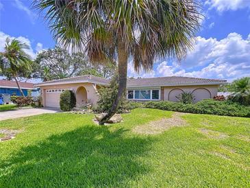 Charming single-story home featuring lush landscaping and a well-manicured lawn at 9631 Oak Ne St, St Petersburg, FL 33702