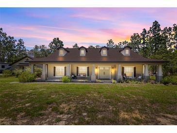 Stunning exterior view of a home with a charming front porch and manicured lawn at 12090 Thames Ave, Weeki Wachee, FL 34614
