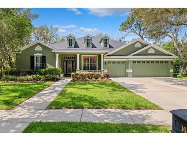Charming one-story home featuring a three-car garage, well-manicured lawn, and attractive landscaping at 16039 Ternglade Dr, Lithia, FL 33547