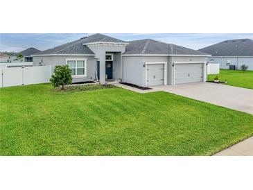 Beautiful home with a lush green lawn, gray exterior, and a two-car garage at 4435 Devinshire Fields Loop, Plant City, FL 33567