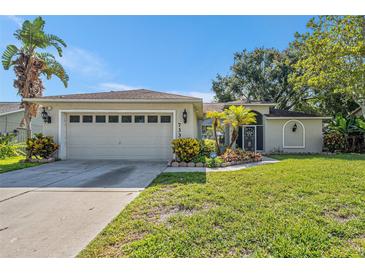 Charming single-story home featuring a well-maintained lawn and attached two-car garage at 7330 Fairwood Ave, New Port Richey, FL 34653