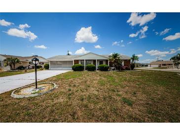 Charming single-story home featuring a well-maintained lawn and screened garage at 801 Oakmont Ave, Sun City Center, FL 33573
