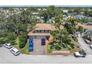 A charming two-story home with a well-manicured front yard and mature trees providing ample shade at 8263 132Nd St, Seminole, FL 33776