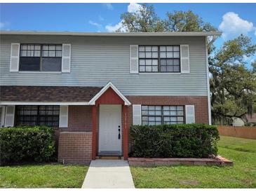 Charming two-story home with vinyl siding, brick accents, white door and white-trimmed windows at 12701 N 57Th St, Tampa, FL 33617