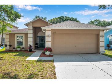 Charming single-story home with a well-manicured lawn, two car garage, and inviting front entrance at 3230 Bellericay Ln, Land O Lakes, FL 34638