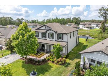 Stunning two-story home with manicured landscaping, mature trees, and charming front porch at 4496 Tatum Loop, Odessa, FL 33556