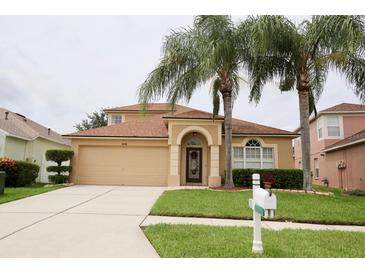 Well-maintained home with a two-car garage, arched entryway, and lush lawn and landscaping at 4535 Gateway Blvd, Wesley Chapel, FL 33544