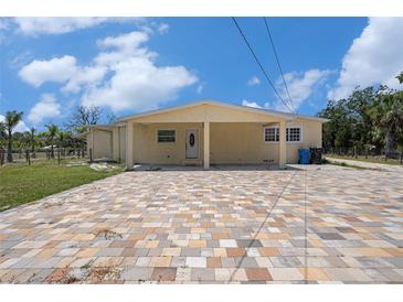 Charming home with a covered entrance, brick paver driveway, and well-maintained lawn at 5012 Troydale Rd, Tampa, FL 33615