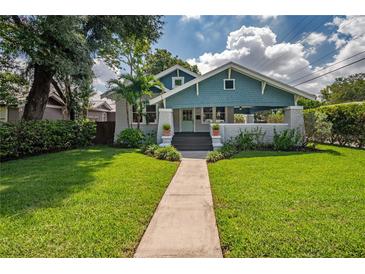Charming home featuring a landscaped front yard, inviting porch, and classic architectural details at 5301 N Central Ave, Tampa, FL 33603