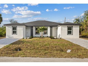 Inviting exterior of a newly constructed home featuring a fresh white facade and well manicured lawn at 6977 Hawksbury St, Englewood, FL 34224