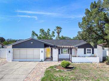 Charming single-story home featuring a yellow front door and well-maintained front yard at 7131 Vista Way, Port Richey, FL 34668