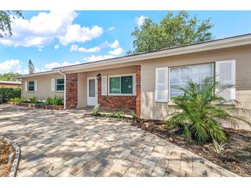 Charming single-story home with brick accents, lush landscaping, and a beautifully paved driveway at 9810 N 53Rd St, Temple Terrace, FL 33617